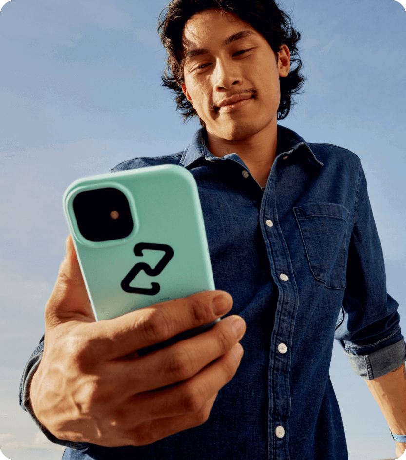 a man in a denim shirt is taking a selfie with his phone